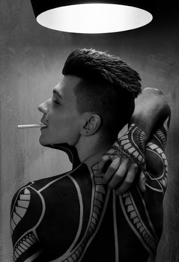 man with tattoo with white cigarette stick on mouth