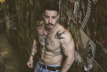 Man With Tattoos Standing Beside Wall 