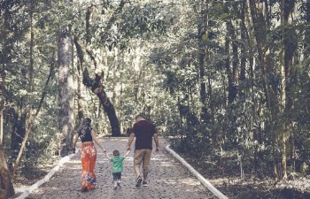 Man, Woman, and Child Walking on Walkway