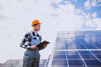 Man worker in the firld by the solar panels Free Photo
