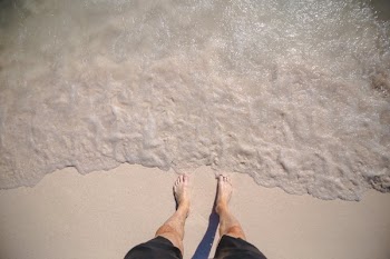 Mans Feet On Ocean Shore