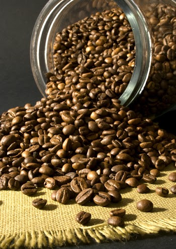 many Coffee beans in and out of a jar of glass
