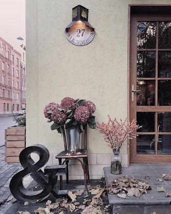 Maroon Flower Bouquet Under Black and White Wall-mount Light Mounted on Beige Concrete Wall