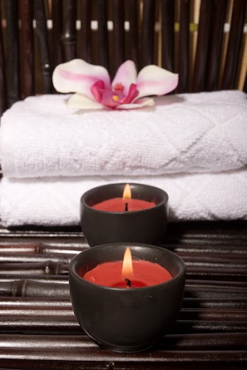 Massage stones and orchid flowers on bamboo