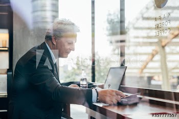 Mature businessman working on laptop in bar