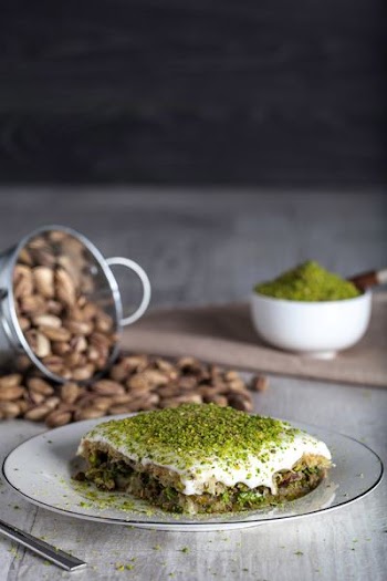 meat with cheese and green vegetable toppings on plate