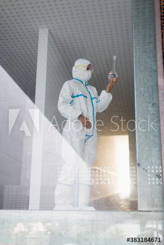 Medical scientist examining beaker in science laboratory