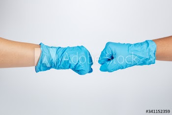 Medical staff bumping fists to support each other during coronavirus pandemic