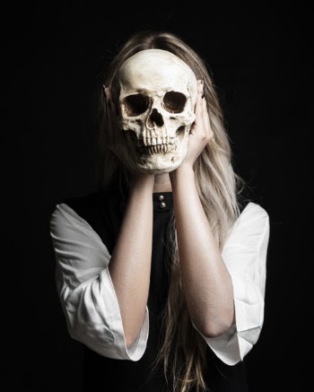 Medium shot of woman holding human skull Free Photo