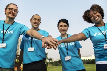 Men And Women Combining Hands Together While Smiling