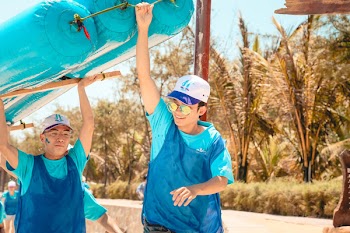 Men in Blue Holding Blue Boat