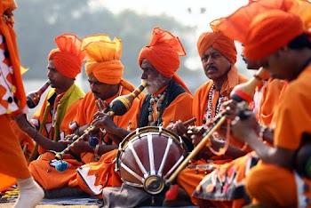 Men in Orange Costumes Playing Instruments