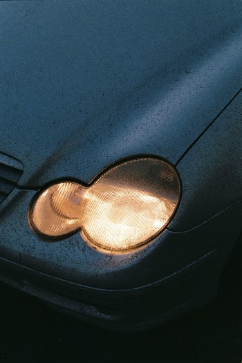 Mercedes-Benz headlight minimalist photograph. Love this because it was taken at sunset and the contrast between the blue shadows and the yellow highlights really makes it stand out to give a lonely roadtrippy vibe.