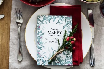 Merry Christmas Card On Plate Between Fork And Knife