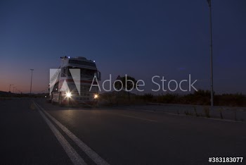 Milk tanker driving on rural road at night