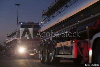 Milk tankers on road at night