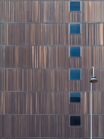minimalist photography of arch post lamp near high-rise building