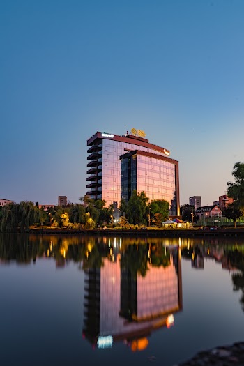 Mirror Glass Facade Of A High-rise Building Near Lake Under Clear Blue Sky