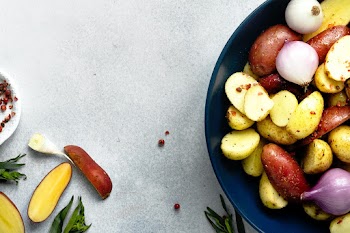 Mixed roasted potatoes with red onions food photography