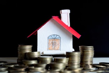 Model of house with coins on wooden table Free Photo