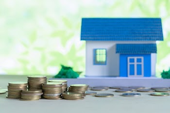 Model of house with coins on wooden table Free Photo