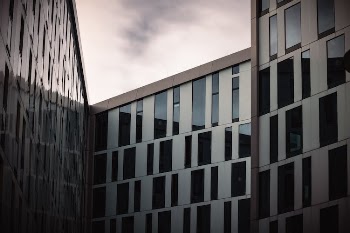 Modern Concrete Building with Glass Panels Under a Gray Sky