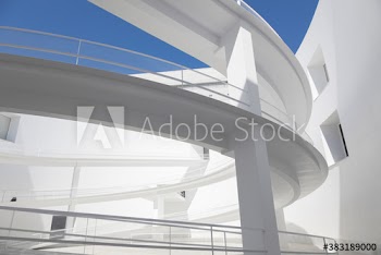 Modern curving ramps in sunny building courtyard