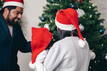 Mom And Dad Show Young Child The Christmas Tree