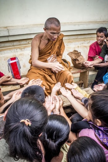 Monk Handing Towards Kids