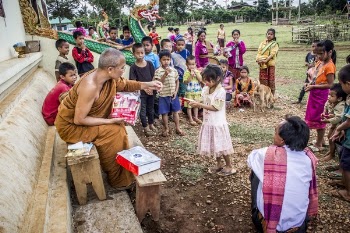 Monk in Front of Children Near Brown Concrete Building