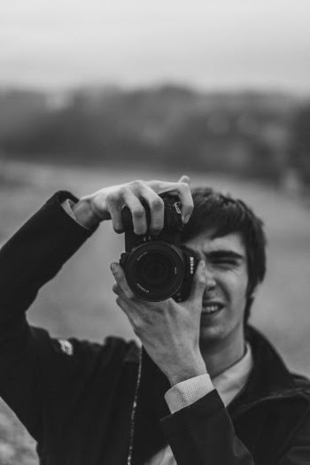 Monochrome Photo of a Man Using a Dslr Camera · Free Stock Photo