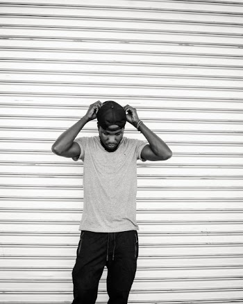 Monochrome Photo of Man Holding His Cap