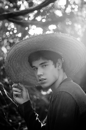 Monochrome Photo of Man Holding His Sun Hat