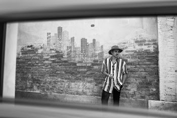 Monochrome Photo of Man Leaning on Brick Wall