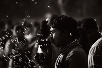 Monochrome Photo Of Man Playing With Bubbles
