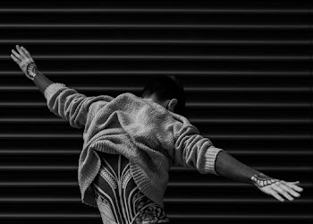 Monochrome Photo of Man Raising His Hands