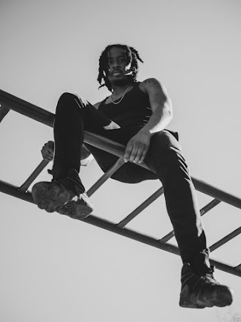 Monochrome Photo of Man Sitting On Horizontal Ladder