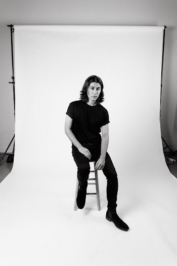Monochrome Photo of Man Sitting on Stool
