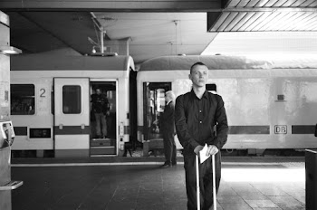 Monochrome Photo Of Man Standing Beside Train