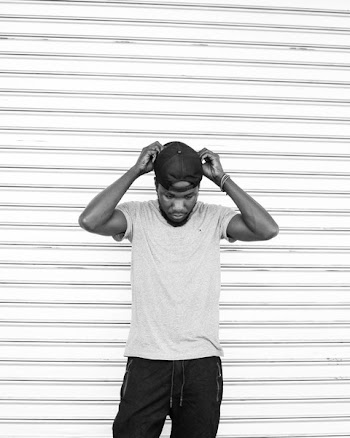 Monochrome Photo of Man Touching His Cap