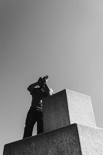 Monochrome Photo of Man Using His Camera