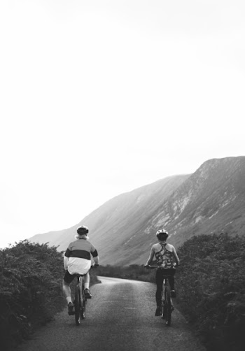Monochrome Photo of People Riding Bicycle