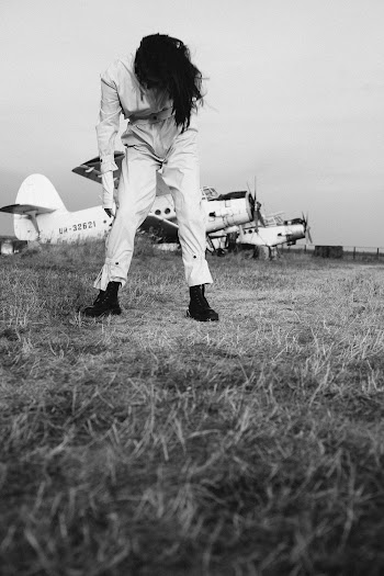 Monochrome Photo of Person Standing on Grass Field