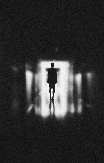 Monochrome Photo of Person Standing on Hallway