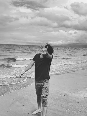 Monochrome Photo of Person Standing on Seashore