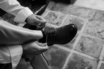 Monochrome Photo of Person Tying Shoes