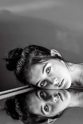 Monochrome Photo of Woman Leaning Her Face On Mirror
