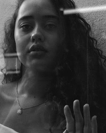 Monochrome Photo of Woman Leaning On Glass