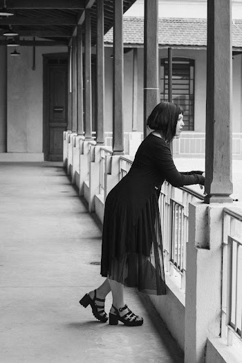 Monochrome Photo of Woman Leaning on Railings