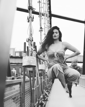 Monochrome Photo of Woman Sitting in Bridge